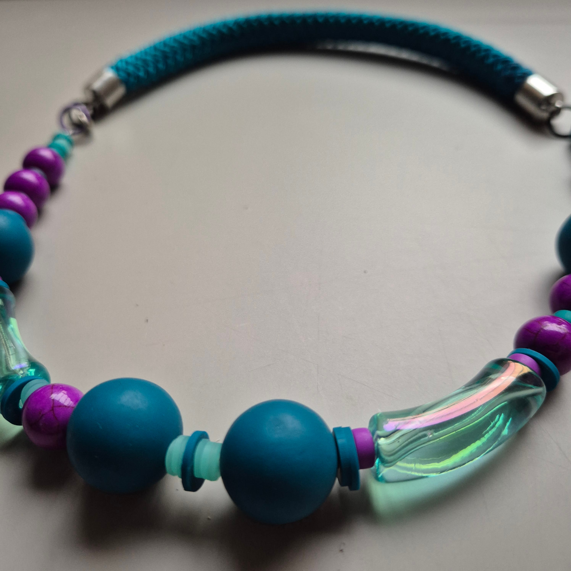 Close view of Frozen with teal spheres, fuchsia crackled beads and iridescent glass tubes