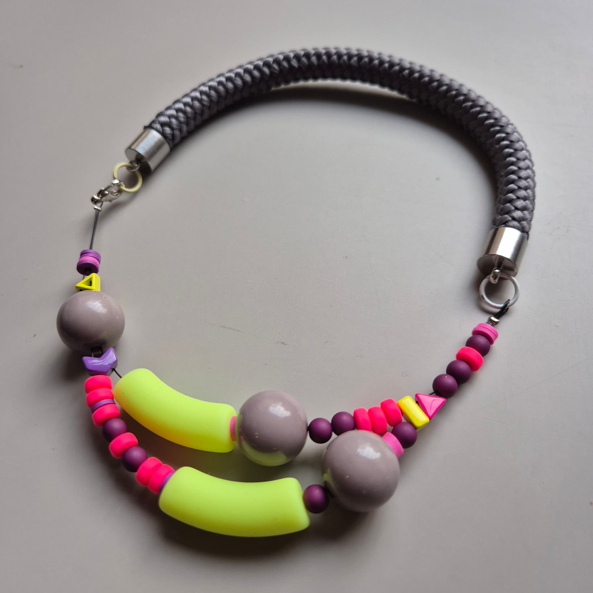 Two-strand necklace with neon yellow tubes, mauve ceramic spheres and plum beads on grey rope