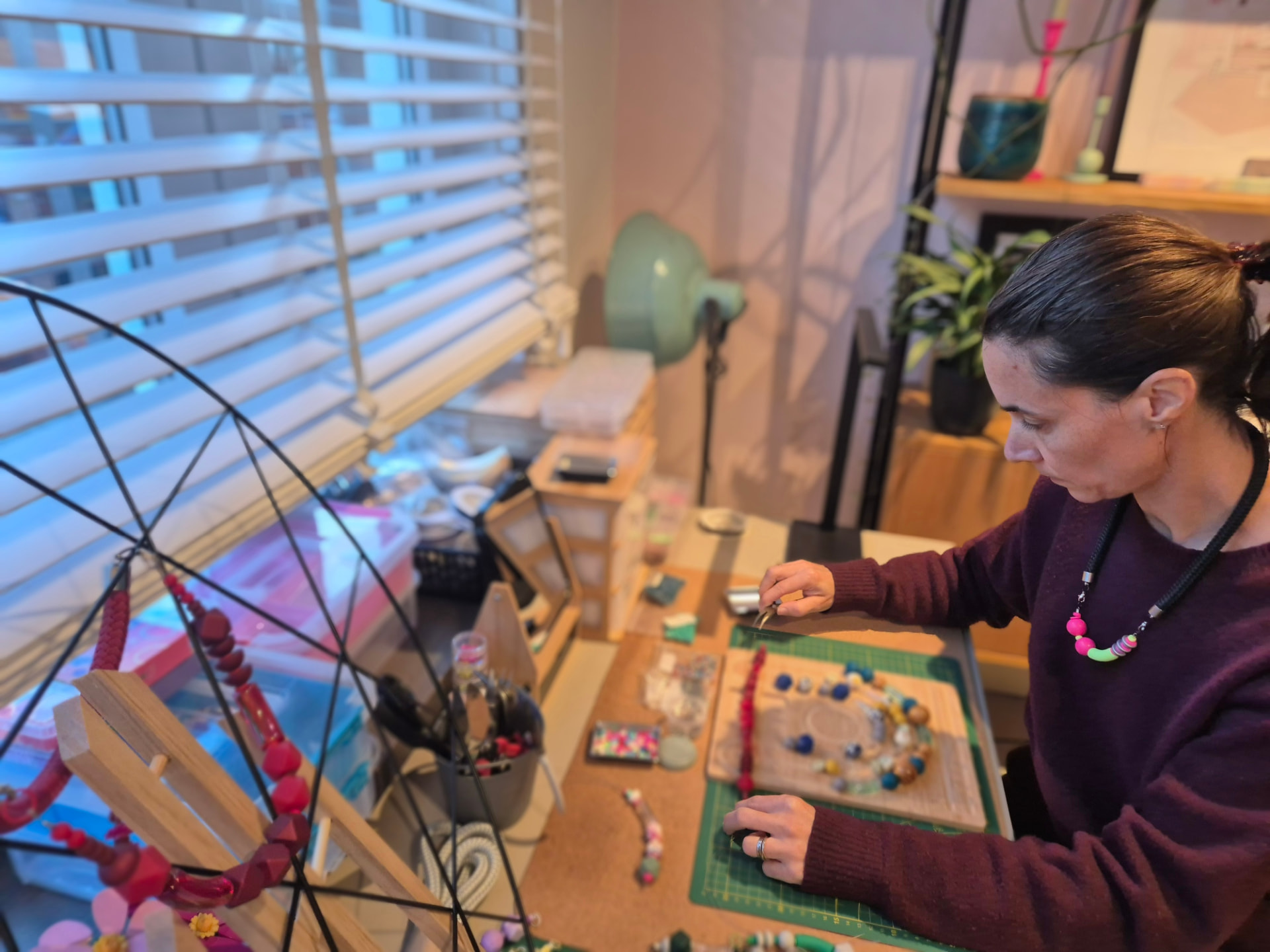 Geneviève composing a necklace at her workbench