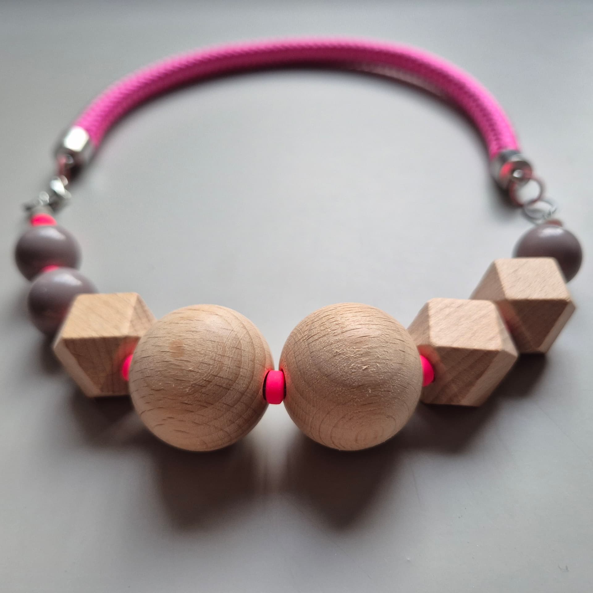 Two large beech spheres flanked by faceted wood cubes and grey ceramic beads